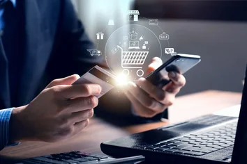 A man holding a smartphone in one hand and a payment card in the other, ready to make a digital transaction.